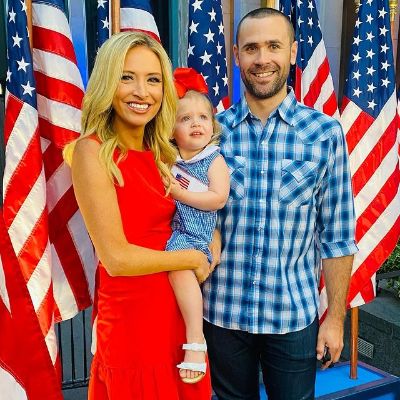 Her mom is holding her as she is surrounded by American flags.